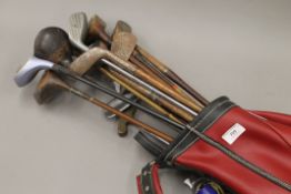 A quantity of various vintage and later golf clubs.