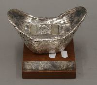 A silver clad Hong Kong Jockey Club trophy mounted on a wooden presentation plinth.