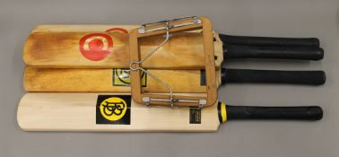 Four vintage cricket bats and a tennis racket clamp.