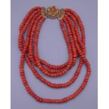 A coral five strand necklace with an 18 ct gold clasp. 40 cm long. 307.4 grammes total weight.