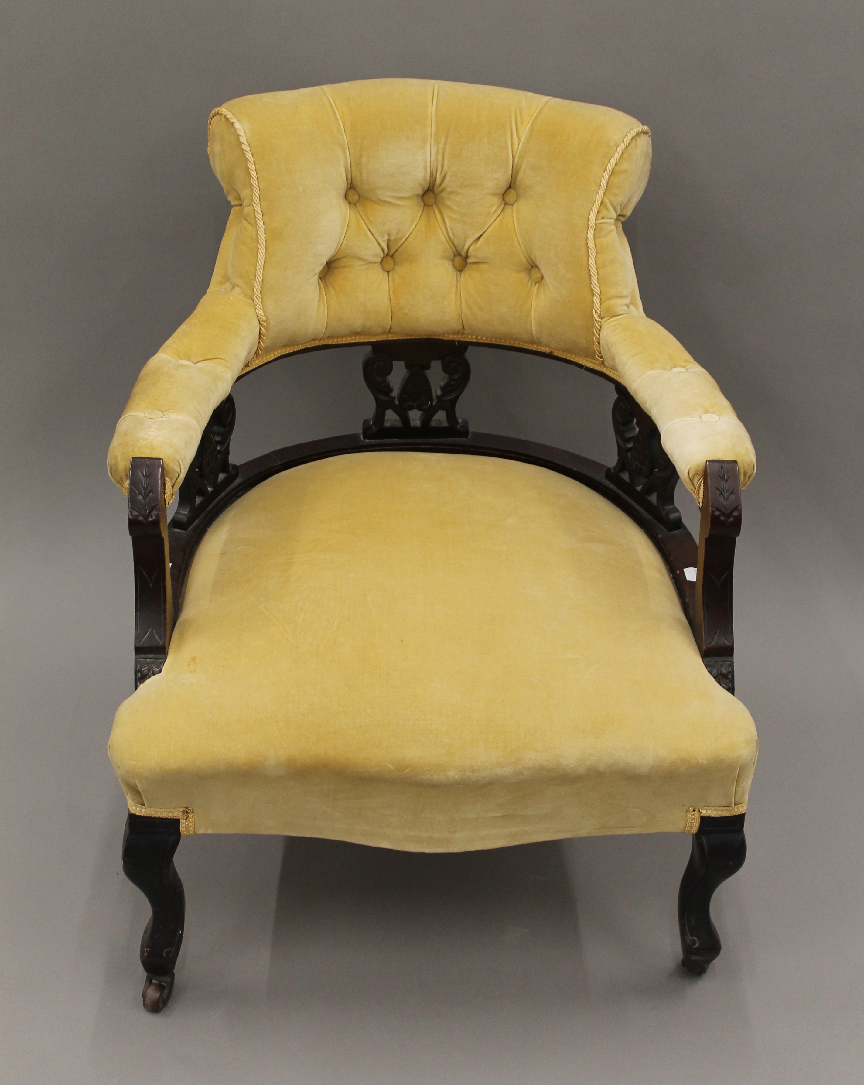 A Victorian upholstered open armchair. 63 cm wide.