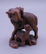 A wood netsuke formed as a goat and kid goat. 4.5 cm high.