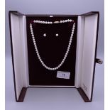 A single strand pearl necklace with matching earrings. Necklace 41 cm long.