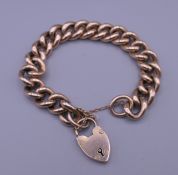 A gold chain bracelet and heart lock. 20 cm long. 26.6 grammes.
