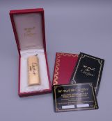 A Cartier lighter, boxed and with guarantee. 7 cm x 2.5 cm.