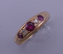 An 18 ct gold ruby and diamond ring. Ring size R/S. 3.9 grammes total weight.