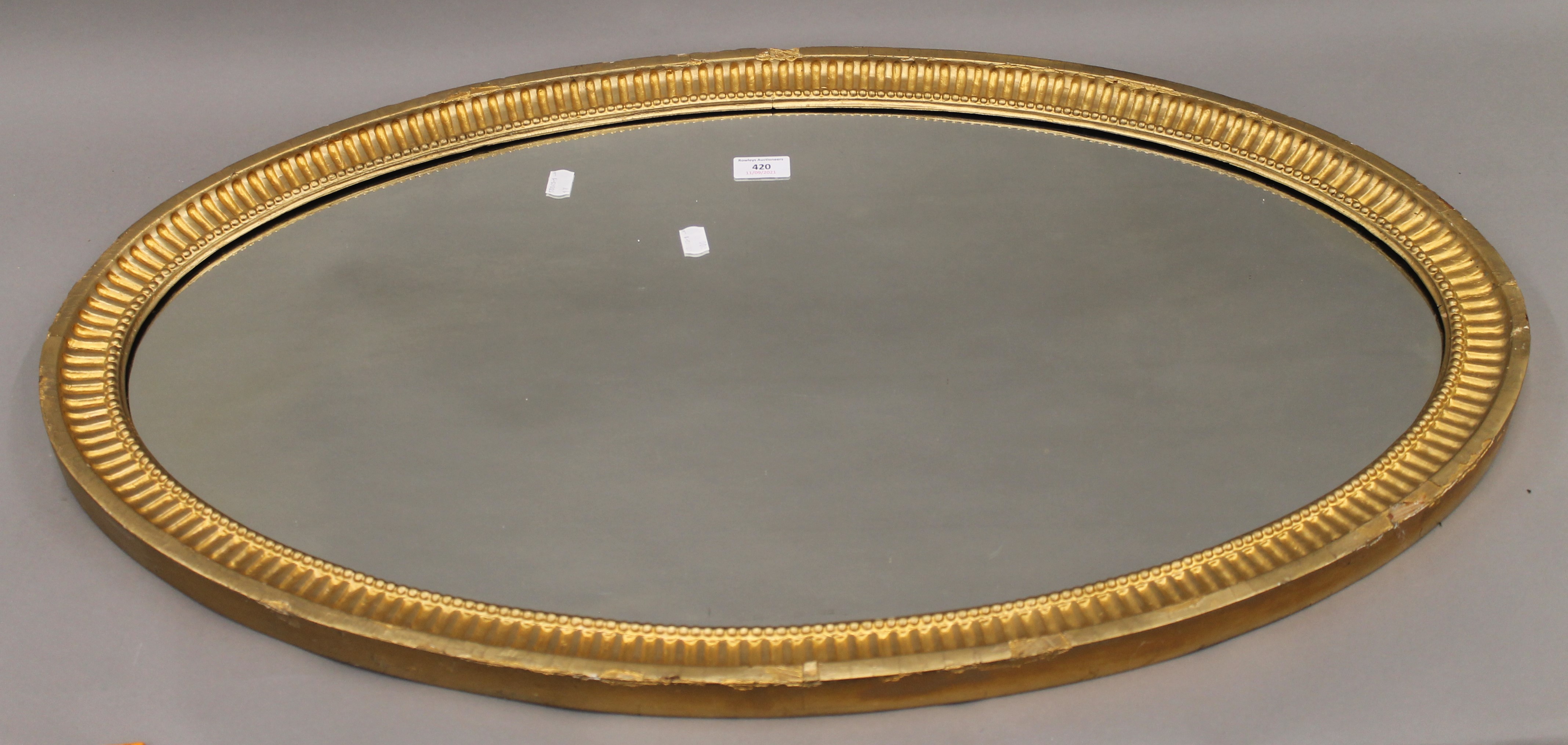 A 19th century oval gilt framed mirror. 90 cm wide, 53 cm high, 3.5 cm deep.