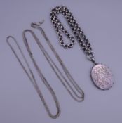 A Victorian silver locket and two chains. Locket 4.5 cm high excluding suspension loop.