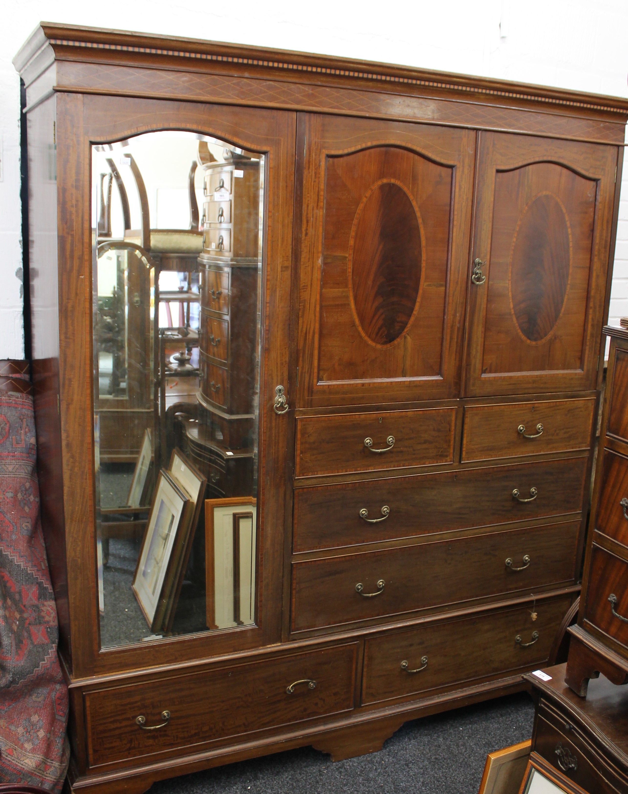 An Edwardian inlaid mahogany compactum wardrobe. 182 cm wide.