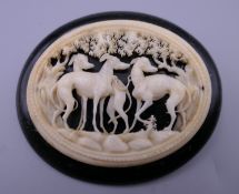 A fine Victorian Whitby jet brooch carved with greyhounds in ivory. 6.5 cm wide.