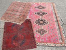 Three red ground wool rugs. The largest 152 x 240 cm.