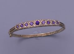 An Edwardian 9 ct gold bangle set with diamonds and amethyst. 13.4 grammes total weight. 5.