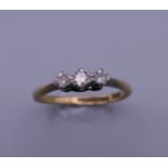 An 18 ct gold and platinum three stone diamond ring. Ring size P. 2.7 grammes total weight.