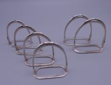 Six stirrup napkin holders. Four 4.5 cm high x 4 cm wide, two 5 cm high x 4.75 cm wide.