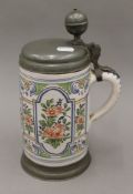 An 18th/19th century German pottery pewter lidded stein with baluster finial thumb piece and