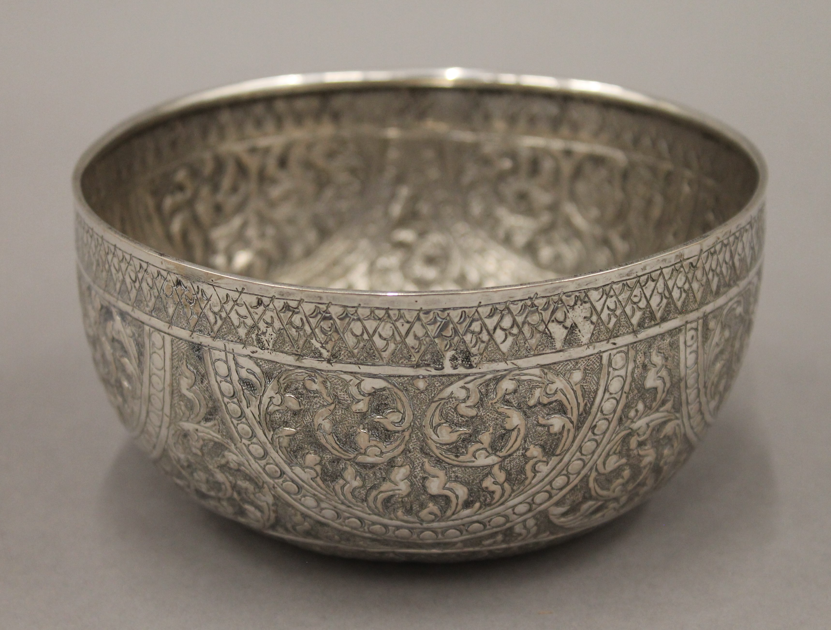 A 19th century hand tooled Thai silver bowl, stamps to base. 14 cm diameter. 115 grammes.