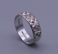 An 18 ct white gold wedding band. Ring size M/N. 3.6 grammes.