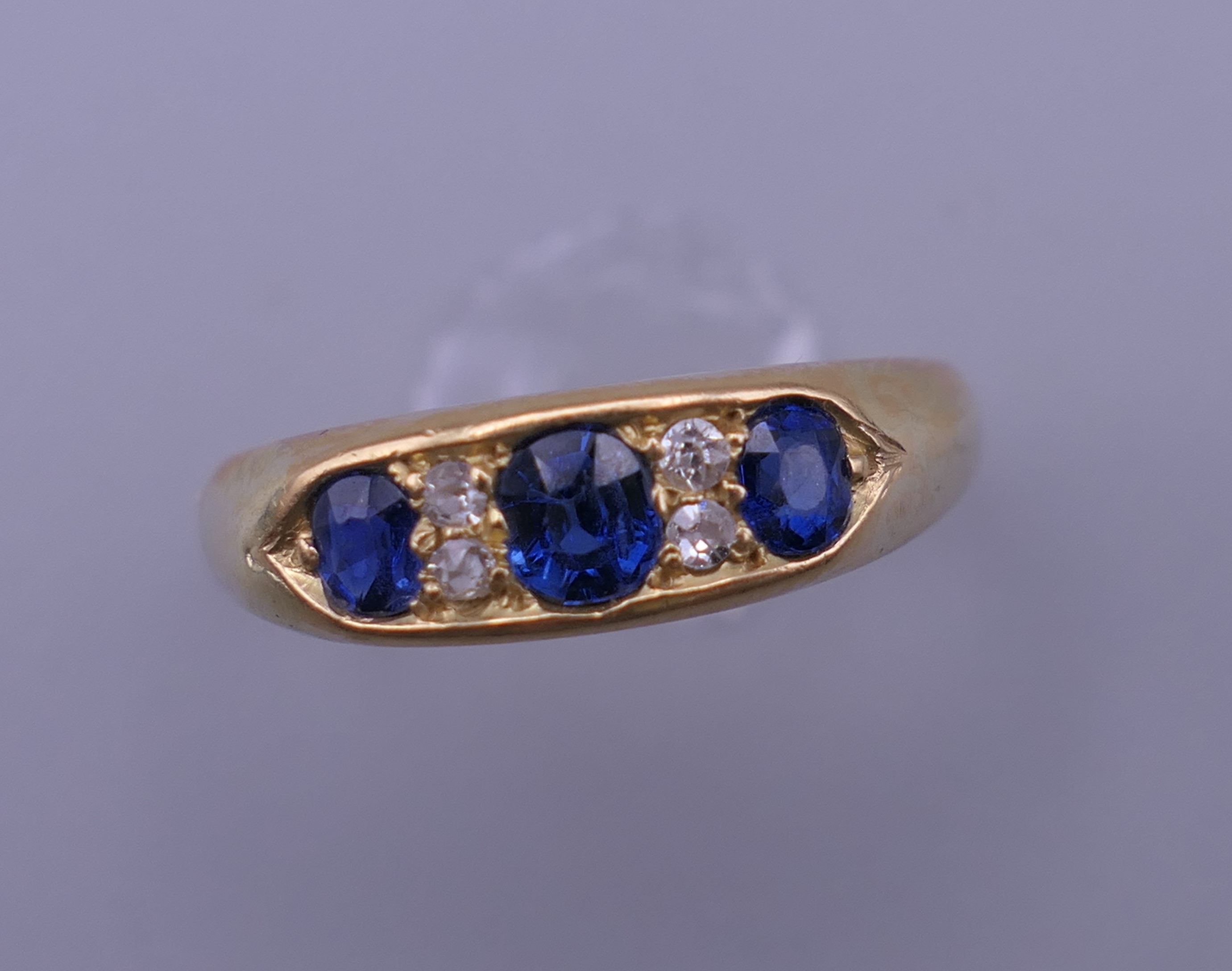 An 18 ct gold diamond and sapphire ring. 5.3 grammes total weight.