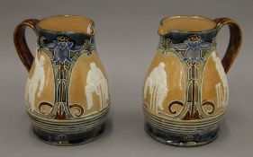 A pair of Doulton Lambeth lemonade jugs decorated with cricketers. Each 14 cm high.