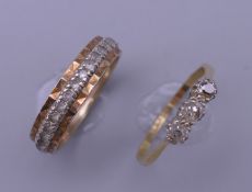 An 18 ct gold and platinum three stone ring (2 grammes total weight) and a gold eternity ring (3.