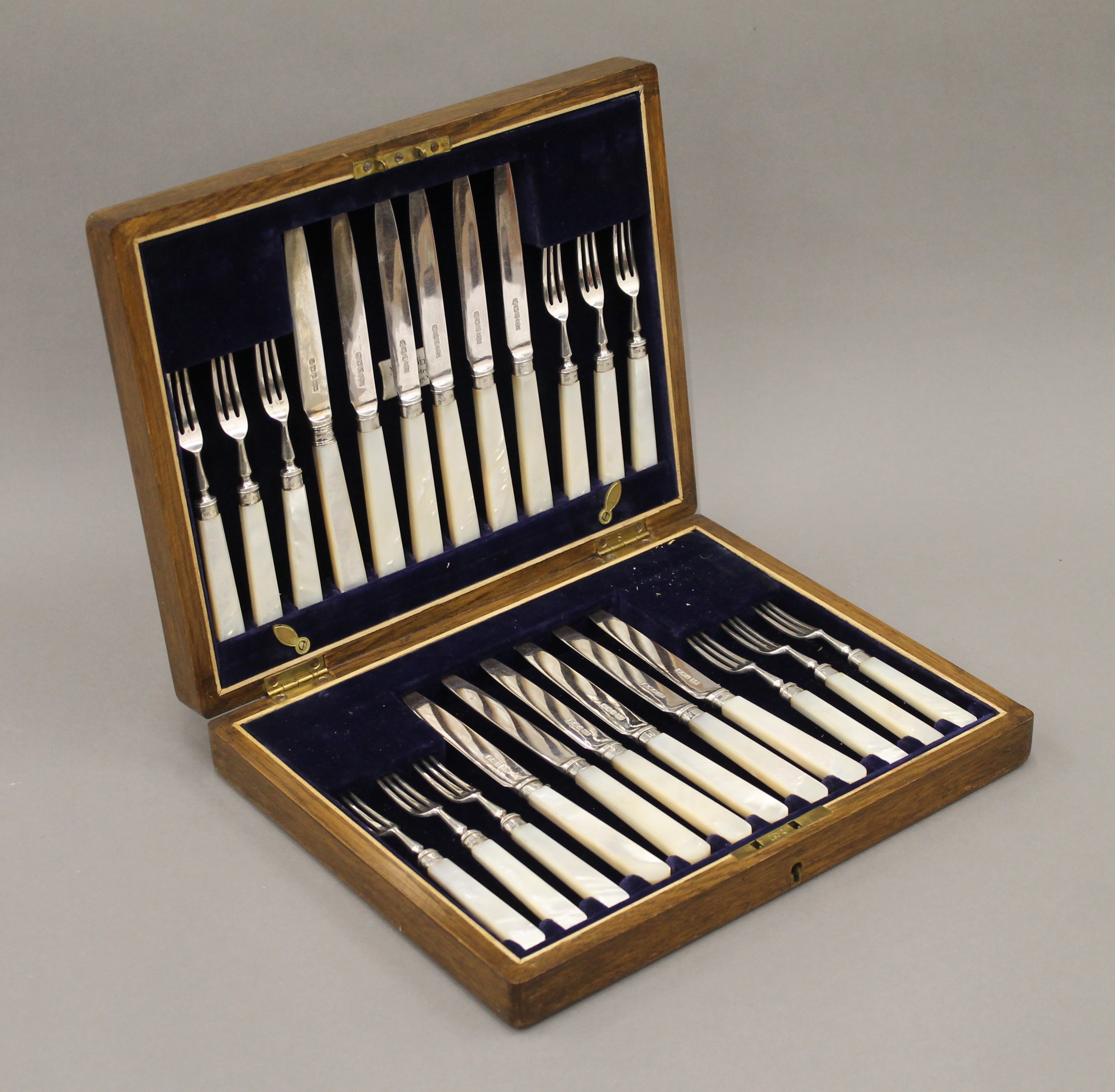 A cased set of mother-of-pearl and silver knives and forks.