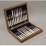 A cased set of mother-of-pearl and silver knives and forks.