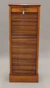 A late 19th/early 20th century walnut tambour fronted filing cabinet. 122 cm high x 47 cm wide.