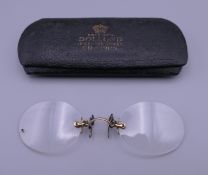 A pair of spectacles in case set with 9 ct gold.