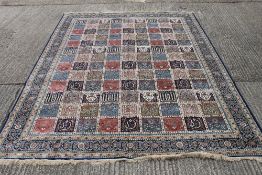 A deep blue ground full pile Kashmir carpet with all over Persian panel design. 380 x 280 cm.