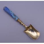A silver enamel caddy spoon, bearing Russian marks. 16.5 cm long.