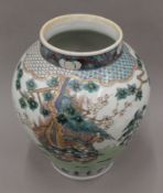 An Oriental porcelain vase of baluster form, painted with birds and foliage. 32.5 cm high.