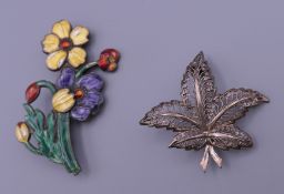 A silver enamel brooch and a silver leaf form brooch. 6.75 cm and 4 cm high respectively.