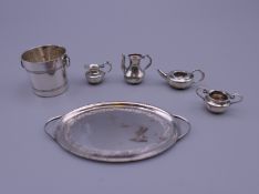 Six pieces of silver dolls house items. Tray 6 cm wide including handles, ice bucket 2 cm high. 25.