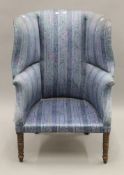 A 19th century upholstered wing back tub armchair. 105 cm high x 73 cm wide.