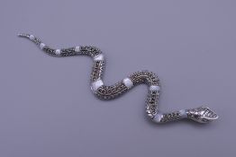 A silver and mother-of-pearl snake form pendant. 12 cm long.