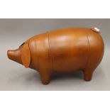 A leather pig footstool. 66 cm long.