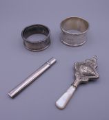 Two silver napkin rings, a baby's rattle and a silver fruit knife. Rattle 9 cm high.