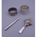 Two silver napkin rings, a baby's rattle and a silver fruit knife. Rattle 9 cm high.