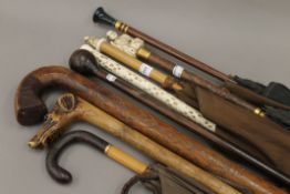 A collection of late 19th/early 20th century walking sticks and umbrellas,