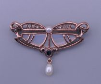 An Art Nouveau style 10 K gold, pearl and diamond brooch. 4.5 cm wide, 3 cm high. 6.