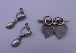 A silver Georg Jensen brooch and matching earrings. Brooch 4.25 x 3cm, earrings 3.5 cm long. 19.