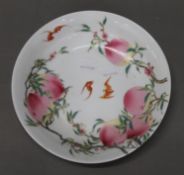 A Chinese porcelain dish decorated with peaches and bats. 20 cm diameter.