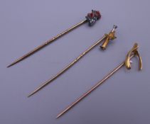 An unmarked fox head and hunting horn stick pin,