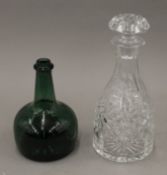 A cut glass decanter and a green glass bottle. The former 26 cm high.