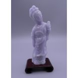 A lavender jade carving of Guanyin, on a small wooden stand. 11 cm high overall.