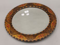 An early 20th century pokerwork mirror. 47 cm diameter.