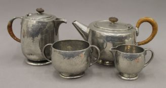 A pewter Tudric four-piece tea set. The teapot 22 cm long.