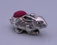 A silver rabbit form pin cushion. 4 cm long.