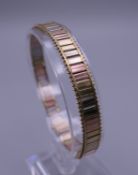 A 9 ct tri-coloured gold bracelet. 7 cm long. 11.6 grammes.