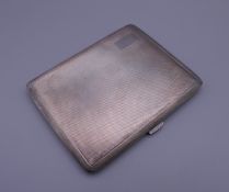 A silver cigarette case in slip. 10.5 cm wide. 117.2 grammes.